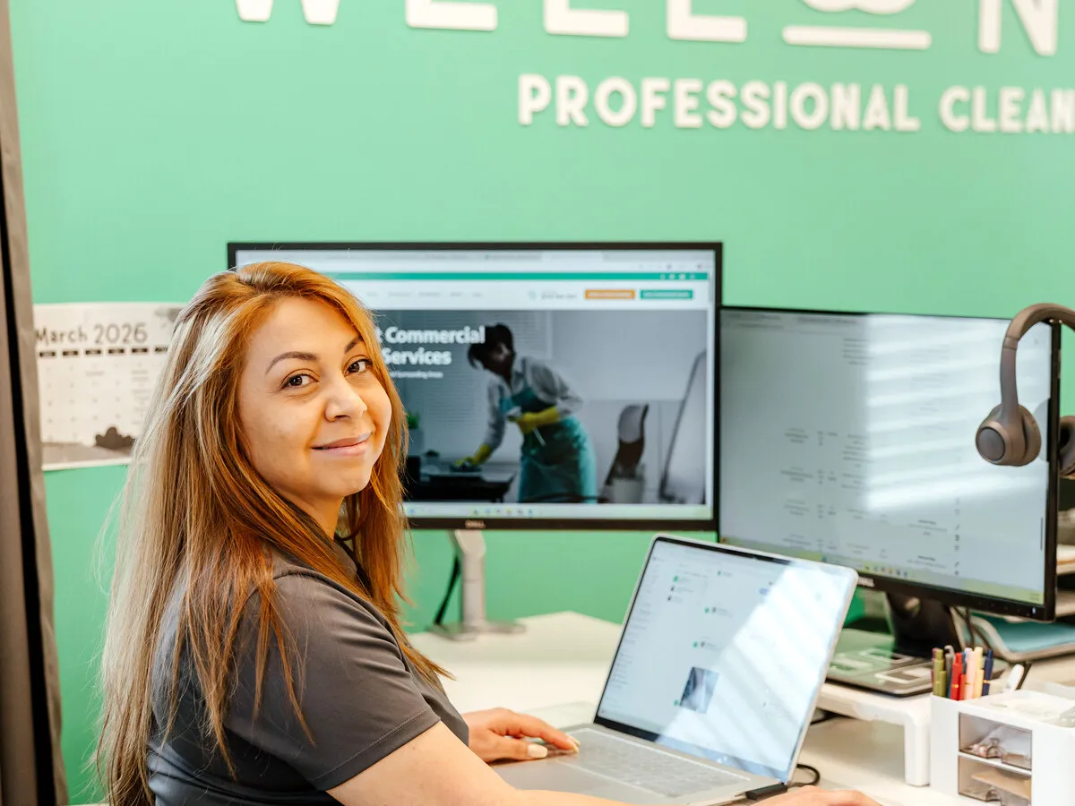 WellNest team member at a computer in the company's Northern Virginia office, managing client cleaning schedules